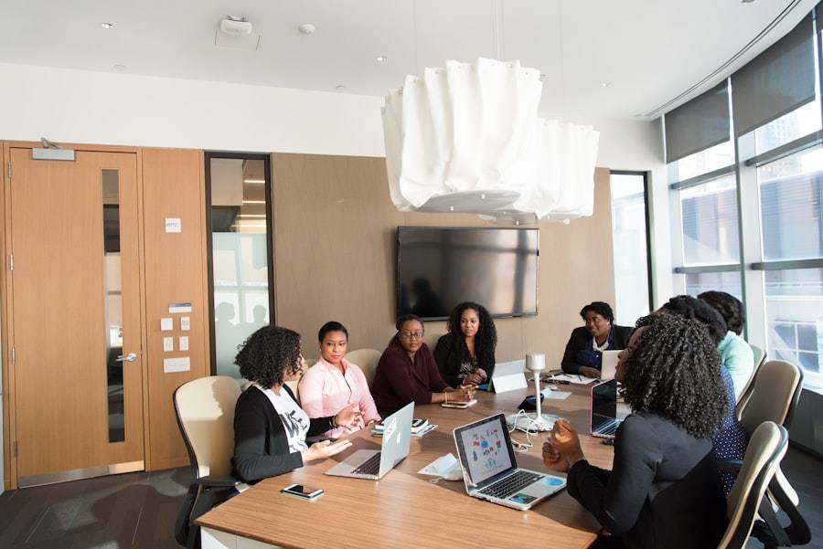 Colleagues talking around a conference table with laptops open